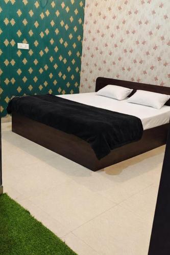 a bed in a room with a black bed frame at Pakwan Restaurant and Rooms in Gorakhpur