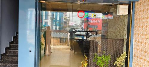 a glass door of a store with a red sign in it at Pakwan Restaurant and Rooms in Gorakhpur