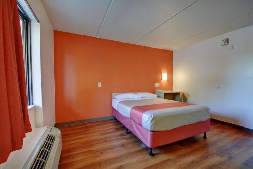 a bedroom with two beds and an orange wall at Motel 6-Chicopee, MA - Springfield in Chicopee