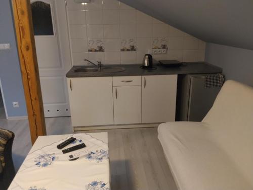 eine kleine Küche mit einem Waschbecken und einem Tisch in der Unterkunft Agroturystyka U Zosi Bałtów in Bałtów