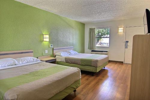 a hotel room with two beds and a window at Motel 6 Austin, TX - Central Downtown UT in Austin