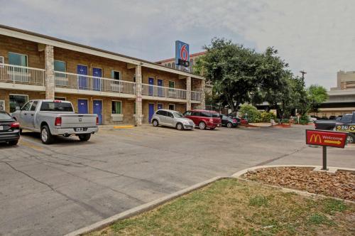 a hotel with cars parked in a parking lot at Motel 6-San Antonio, TX - Downtown - Market Square in San Antonio