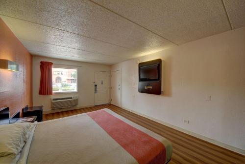 a bedroom with a bed and a tv on the wall at Motel 6-San Antonio, TX - Downtown - Market Square in San Antonio