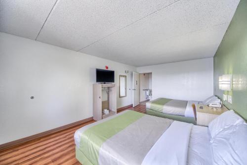a hotel room with two beds and a flat screen tv at Motel 6-San Antonio, TX - Northwest Medical Center in San Antonio