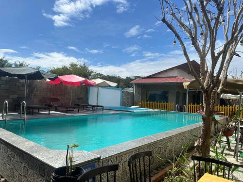 ein Schwimmbad mit Stühlen und Sonnenschirmen in der Unterkunft Homestay Bích Huệ Nova Phan Thiết in Bình Tú