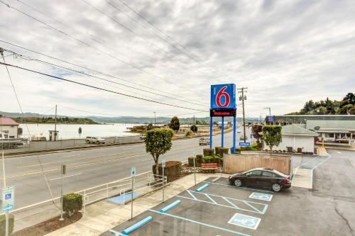 a gas station with a car parked in a parking lot at Motel 6-Coos Bay, OR in Coos Bay