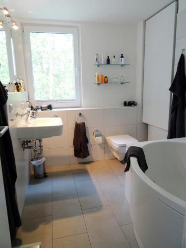 a bathroom with a tub and a sink and a toilet at Deichhaus Boddentraum in Breege