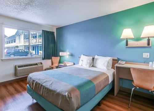 a hotel room with a bed and a desk and a window at Motel 6-Coos Bay, OR in Coos Bay