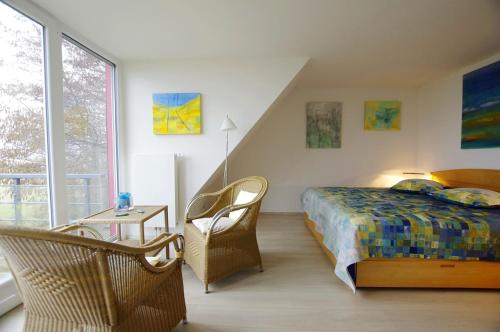 a bedroom with a bed and a chair and a window at Deichhaus Boddentraum in Breege
