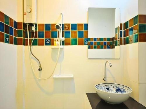 een badkamer met een wastafel en een douche bij Baan Saranrom in Amphawa