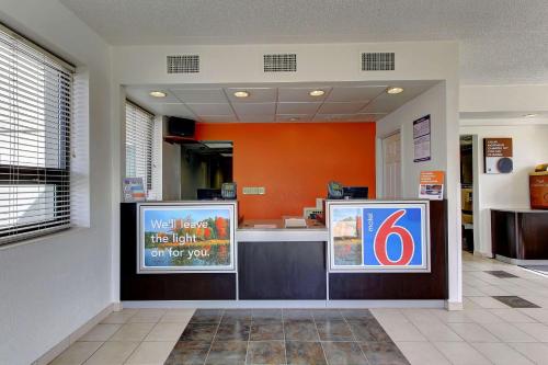 a waiting area of a store with an orange wall at Motel 6-York, PA - North in York
