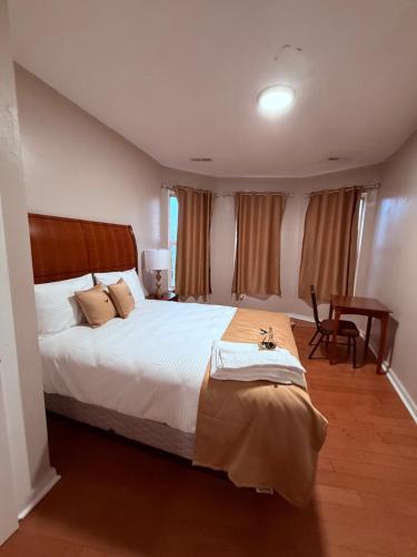 een slaapkamer met een groot bed en een bureau bij Eagle Pamir Guest House in New Haven