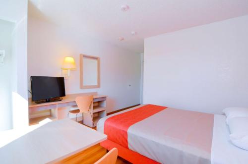 a hotel room with a bed and a desk with a television at Motel 6-North Palm Springs, CA - North in North Palm Springs