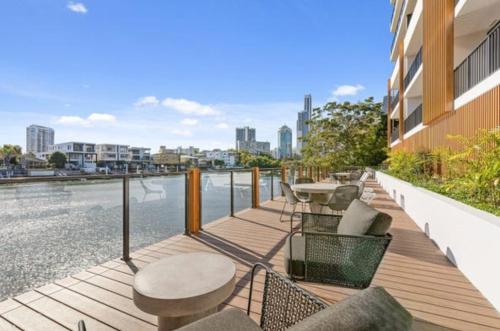 a balcony with tables and chairs next to a body of water at Surfers paradise Luxury 2BR River View Retreat in Gold Coast