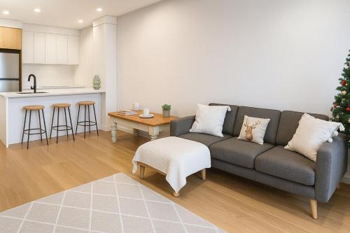 a living room with a couch and a kitchen at Surfers paradise Luxury 2BR River View Retreat in Gold Coast