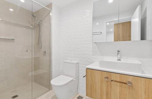 a bathroom with a toilet and a sink and a shower at Surfers paradise Luxury 2BR River View Retreat in Gold Coast