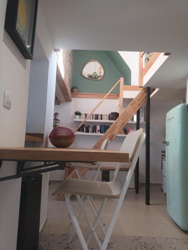 eine Treppe in einem Zimmer mit einem Tisch und einem Stuhl in der Unterkunft La longère Saint-Eloi 