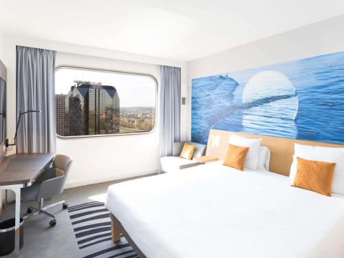 een hotelkamer met een bed, een bureau en een raam bij Novotel Paris Centre Tour Eiffel in Parijs