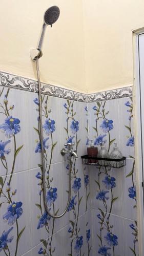 una doccia con fiori blu sul muro di Dream Homestay Sidemen a Silebeng
