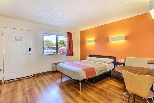 a bedroom with a bed and a table and a window at Motel 6-Campbell, CA - San Jose in Campbell