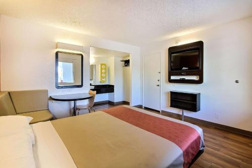a hotel room with a bed and a flat screen tv at Motel 6-Campbell, CA - San Jose in Campbell
