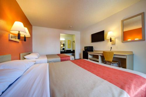 a hotel room with two beds and a desk at Motel 6-Seattle, WA - Airport in SeaTac
