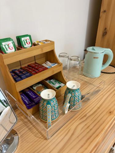 einen Tisch mit zwei Tassen und etwas Essen drauf. in der Unterkunft The Bungalow in Lichfield