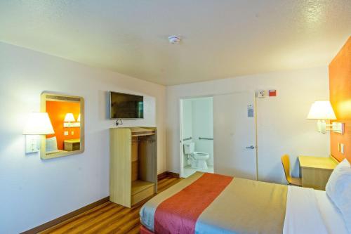 a hotel room with a bed and a bathroom at Motel 6-Redding, CA - South in Redding