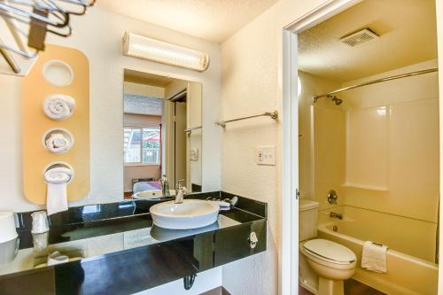 a bathroom with a sink and a toilet and a mirror at Motel 6-Stockton, CA - Charter Way West in Stockton