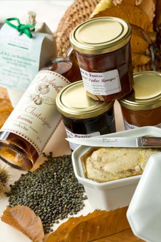 a table topped with jars of jam and seeds at Logis Hotel Spa Restaurant Le Provence in Lanarce