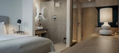 ein Schlafzimmer mit einem Bett und einem Tisch mit einer Lampe in der Unterkunft Sonnhof Alpendorf - an adults only place in St. Johann im Pongau