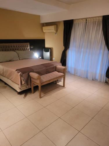 una camera da letto con un letto grande con una panca e tende di Residencia La Serena a Bernal