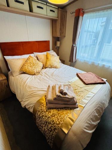 a bedroom with a large bed with towels on it at Princess's Palace, Holiday Lodge, Malvern View Leisure Park in Stanford Bishop