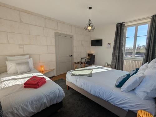 ein Schlafzimmer mit zwei Betten und einem Fenster in der Unterkunft Le Brissonneau in Saint-Saturnin