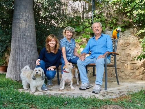 une famille assise sur un banc avec leurs chiens dans l'établissement Casa Son Sant Jordi, à Pollença