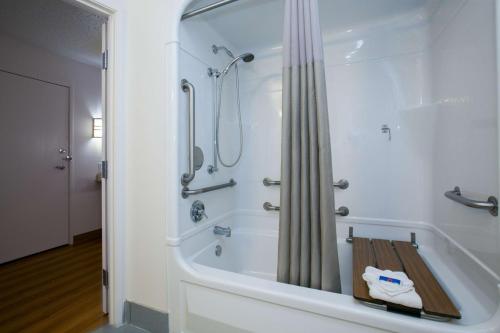a bathroom with a bath tub with a shower at Motel 6-Brooklyn Center, MN - Minneapolis in Brooklyn Center