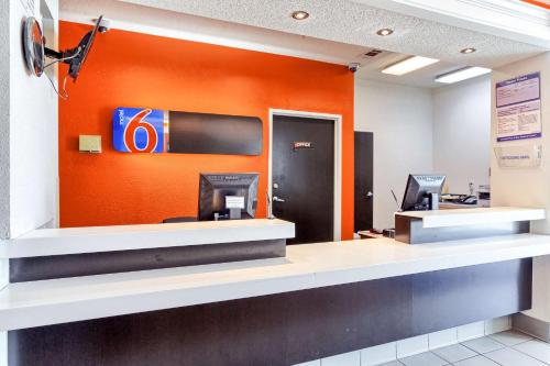 an office lobby with an orange wall at Motel 6-Killeen, TX in Killeen