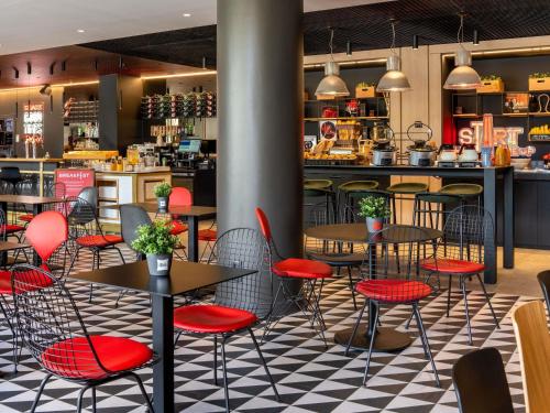 a restaurant with tables and chairs and a counter at Ibis Barcelona Aeropuerto Viladecans in Viladecáns