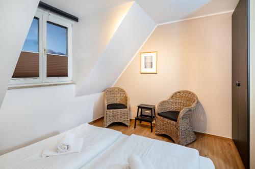 a bedroom with a bed and two chairs at Haus Wittow in Breege