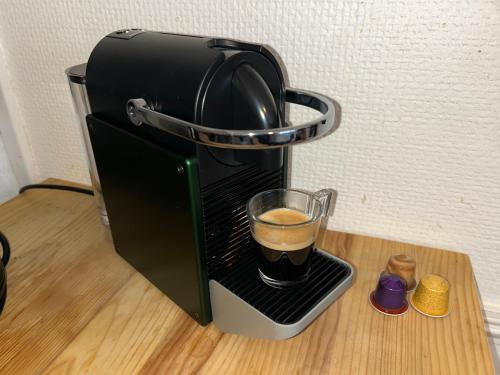 a coffee maker with a cup of coffee at Larcadian in Boulogne-sur-Mer