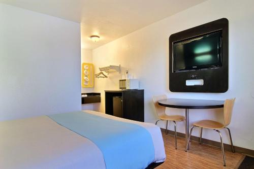 a hotel room with a bed and a table with a tv at Motel 6-Carlsbad, NM in Carlsbad