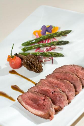 a plate of food with meat and vegetables on it at Logis Hotel Spa Restaurant Le Provence in Lanarce