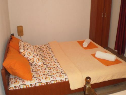 a bedroom with a bed with orange pillows at Apartment Vuk i Novak in Ulcinj