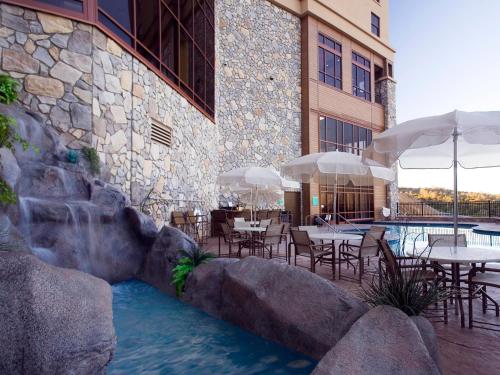 a pool with tables and umbrellas in a resort at Chukchansi Gold Resort & Casino in Coarsegold