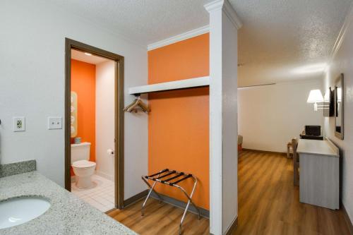 an orange bathroom with a sink and a toilet at Motel 6-Waukegan, IL in Waukegan