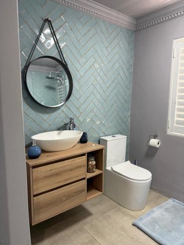 a bathroom with a sink and a toilet and a mirror at Casa Mia in Jeffreys Bay