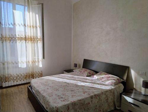 een slaapkamer met een bed en een groot raam bij Bright and cozy apartment in Sesto San Giovanni