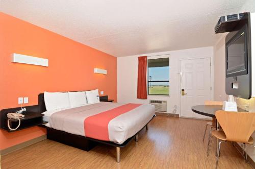 a bedroom with a bed and a desk and a tv at Motel 6-South Haven, KS in South Haven