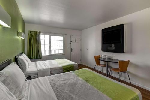 a hotel room with two beds and a flat screen tv at Motel 6-Visalia, CA in Visalia