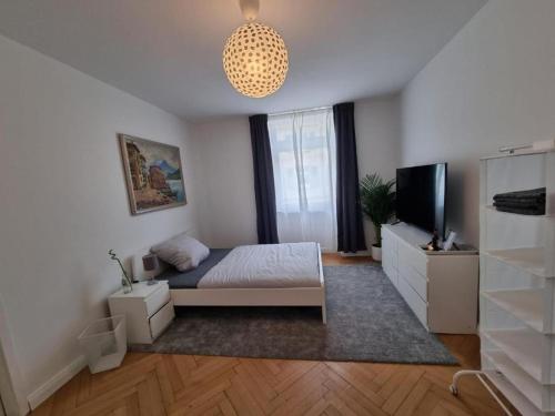 a bedroom with a bed and a television and a chandelier at Süße Marie 2 in Karlsruhe